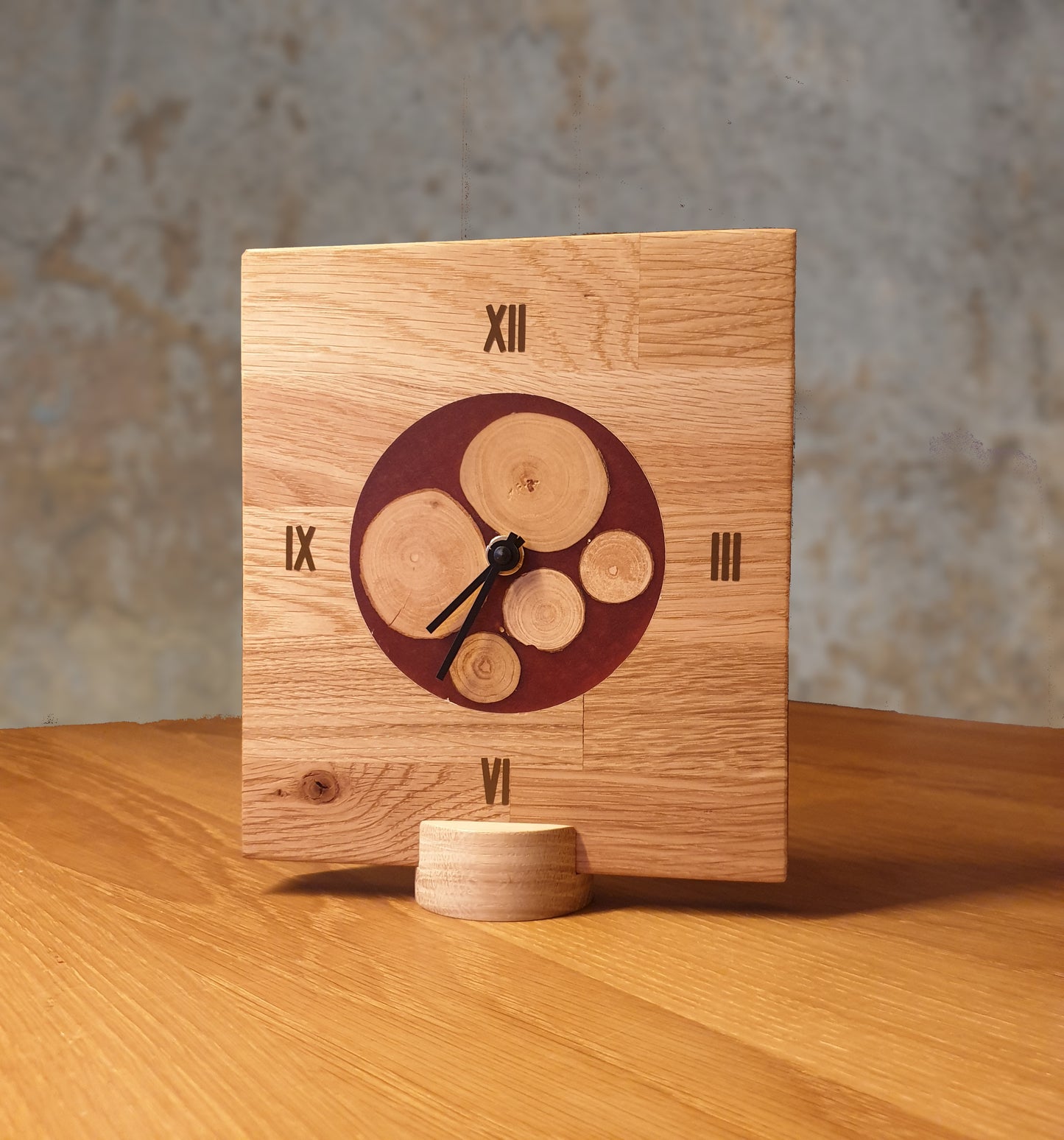 Uhr aus massivem Eichenholz mit Inlay aus kleinen Baumscheiben, eingefasst in weinroten Kunstharz. Leises, geräuscharmen, lautloses Quarzuhrwerk