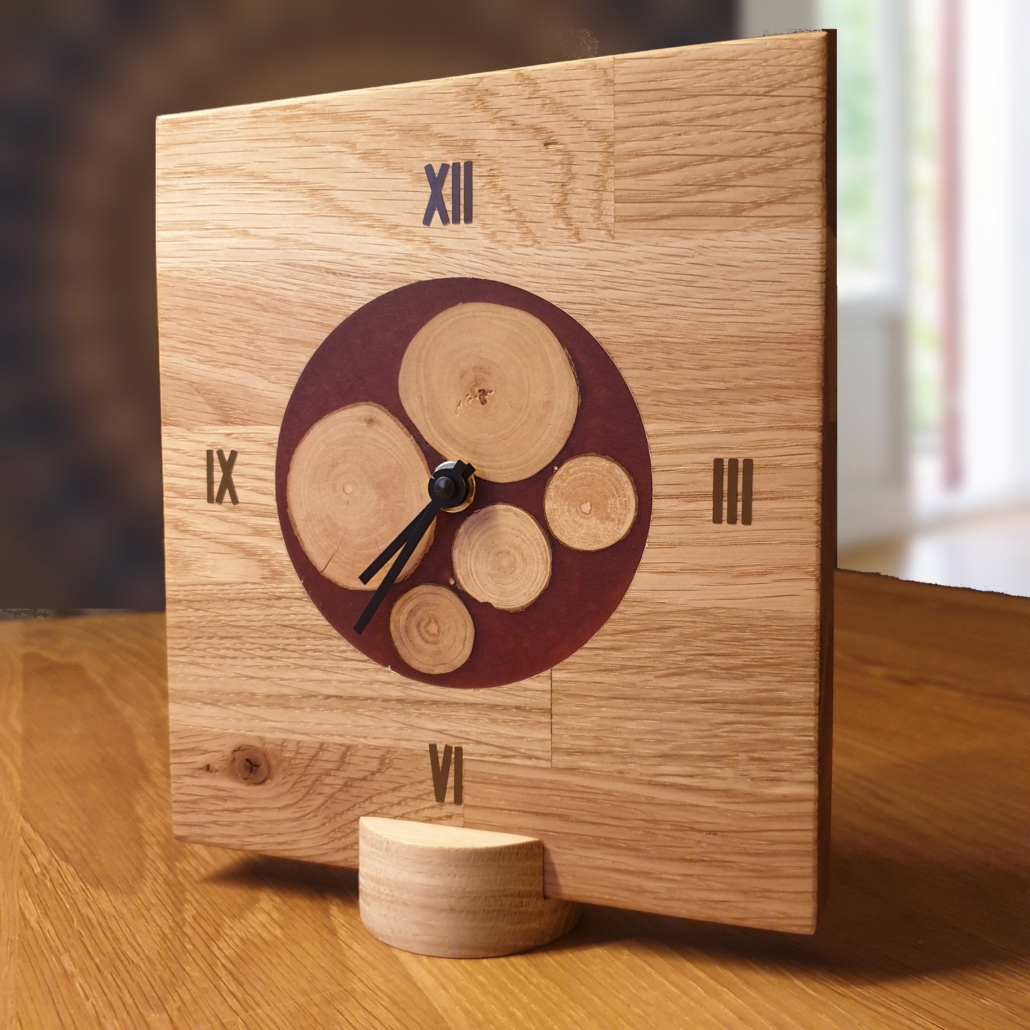 Uhr aus massivem Eichenholz mit Inlay aus kleinen Baumscheiben, eingefasst in weinroten Kunstharz. Leises, geräuscharmen, lautloses Quarzuhrwerk